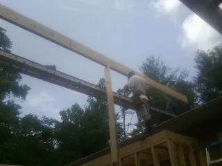 Carpenter setting a ridge beam over a new addition frame — Ice Dam Removal by Roofing Brothers in Amery